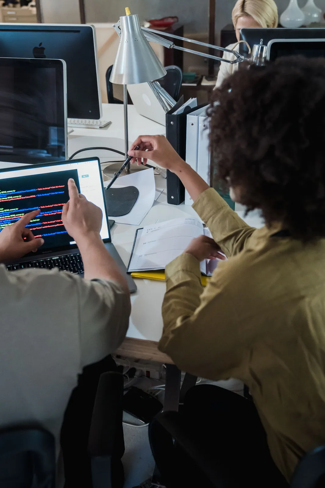 A software team reviewing code together on a laptop.